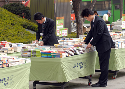 닦아도 닦아도...8일 오전 서울 종로의 한 도서 가판대에서 책에 앉은 황사먼지를 닦아내고 있는 판매원들. 